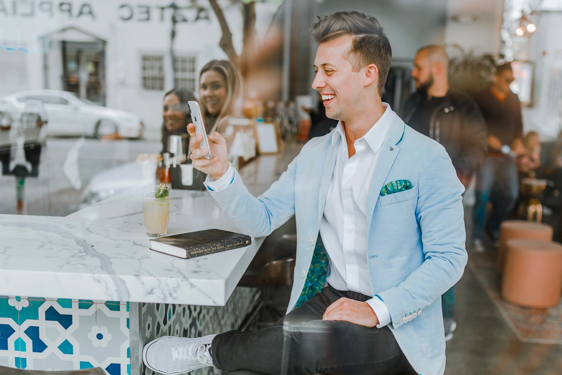 Happy man in cafe using smartphone
