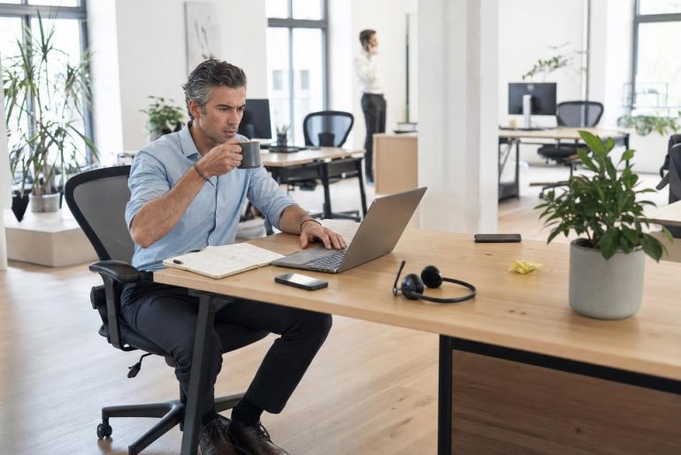 Man working on laptop in a bright office