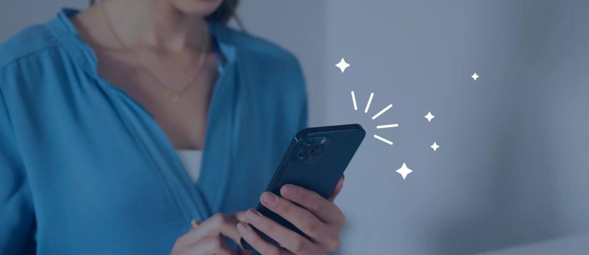 Person lächelt bei der Nutzung eines Smartphones.
