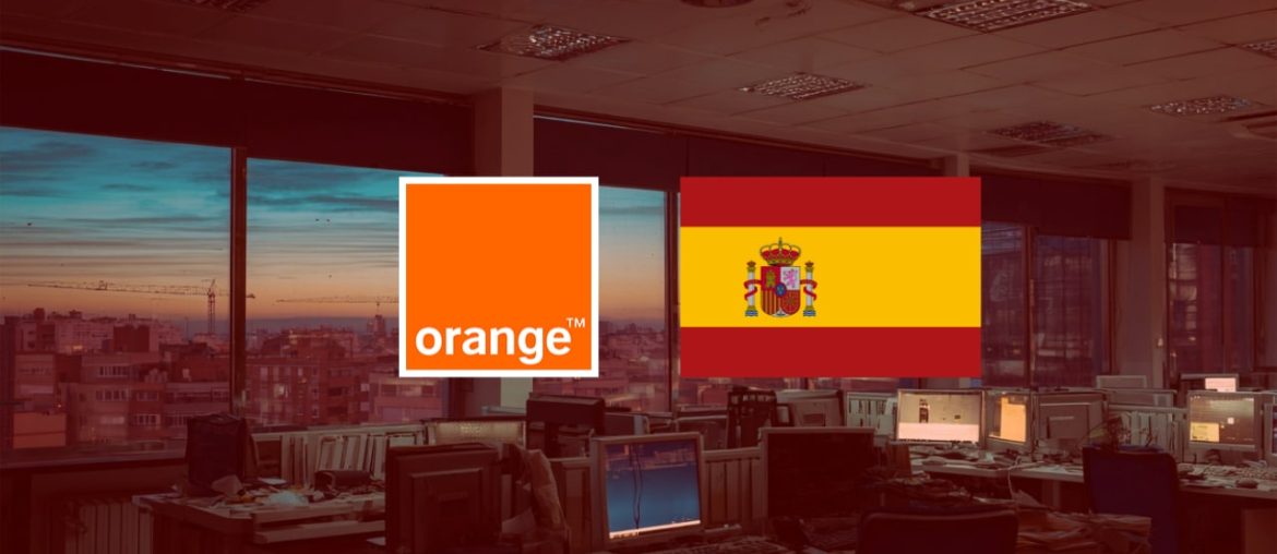 Oficinas al atardecer con logos de empresa y bandera España
