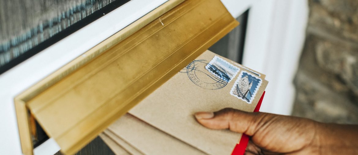 Mano inserisce lettere nella cassetta della posta