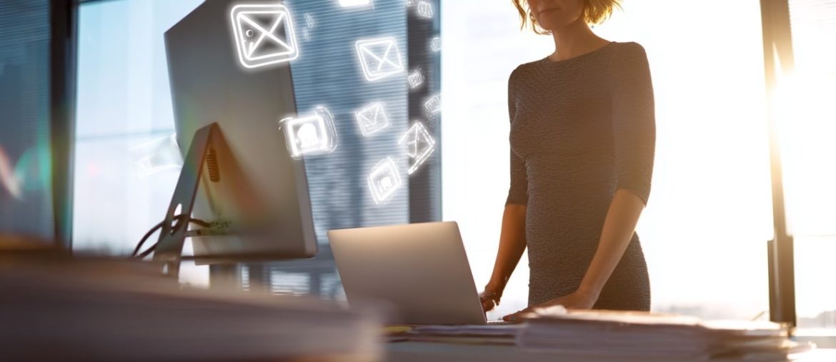 Donna al computer con icone email intorno.