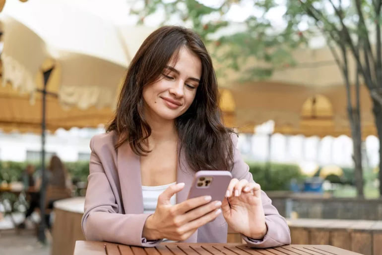 Mulher utilizando um smartphone ao ar livre.